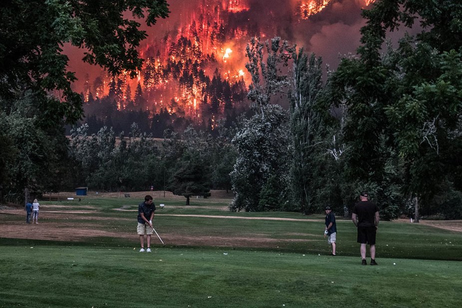 These photos of golfers playing on as an Oregon wildfire rages nearby are absolutely nuts