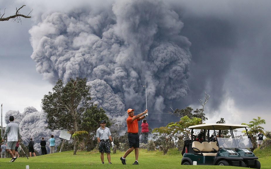 Golfers playing on next to a volcano spewing a plume of ash? Yes, but they were in no danger