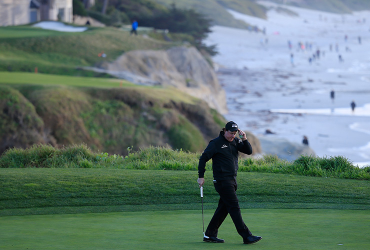 Lefty leads Paul Casey by three with two holes remaining but will have to come back Monday to seal Pebble Beach title