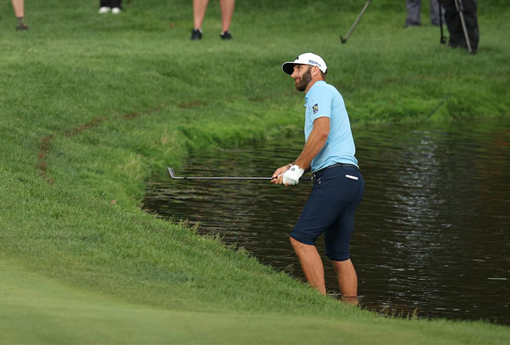 Dustin Johnson goes barefoot to hit recovery shot after his ball miraculously stays out of the water