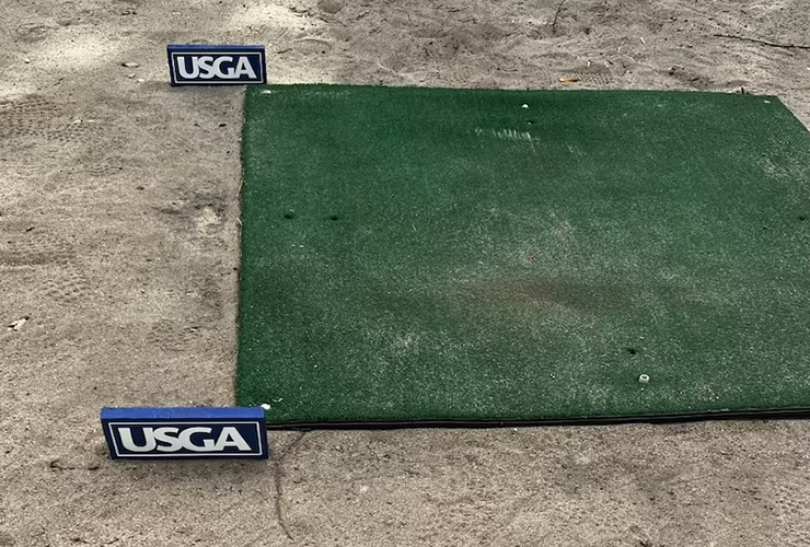 Why were range mats used for tee boxes at USGA qualifier?